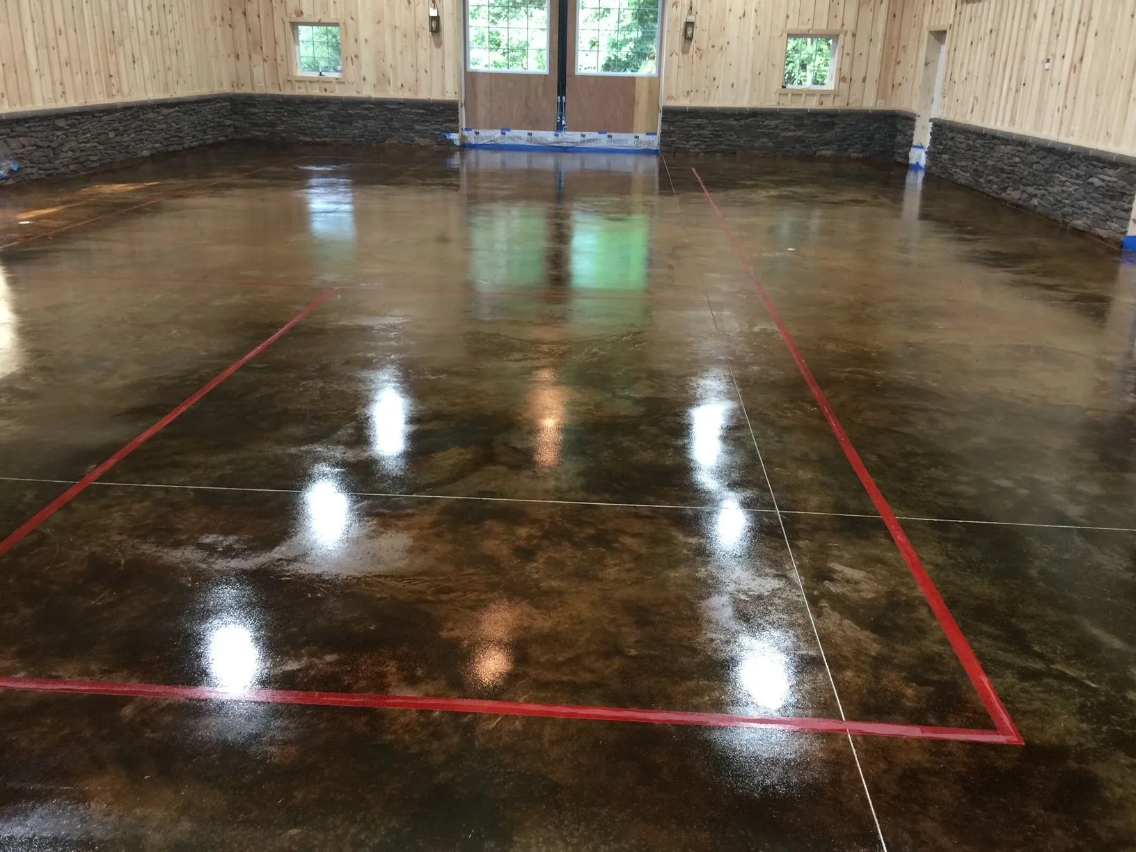 A large room with a shiny concrete floor and a red line on the floor.