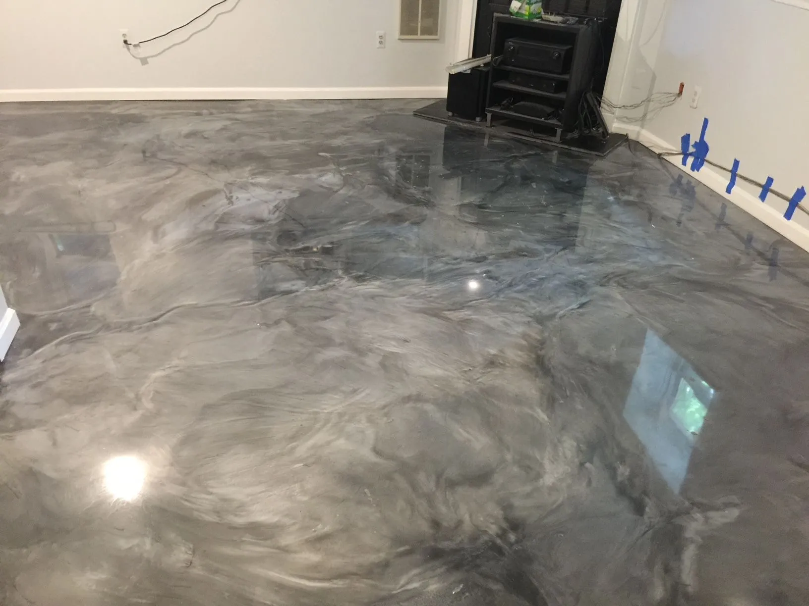 A room with a shiny concrete floor and a fireplace