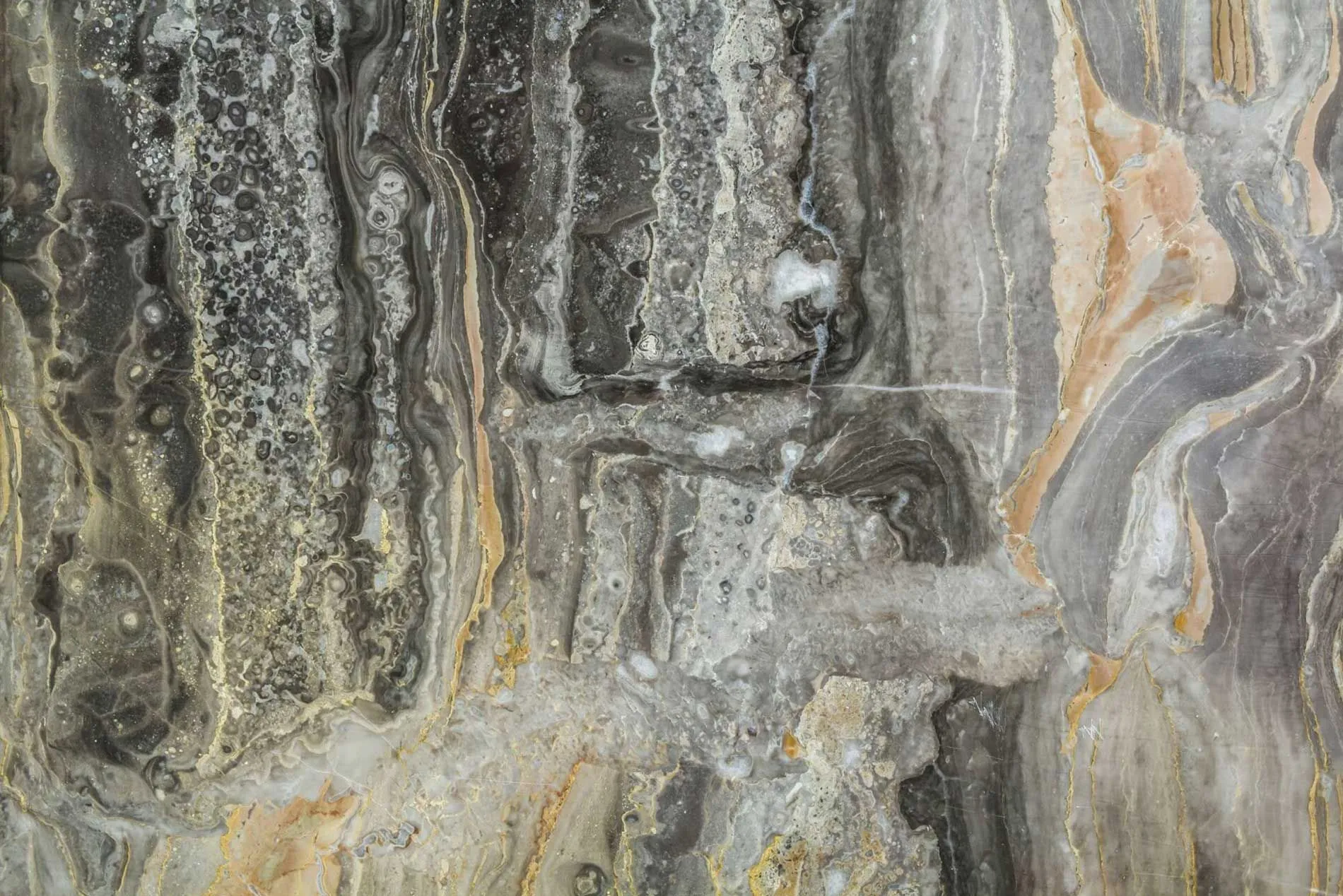 Close-up of metallic epoxy flooring with grey, black, and gold marbled swirls